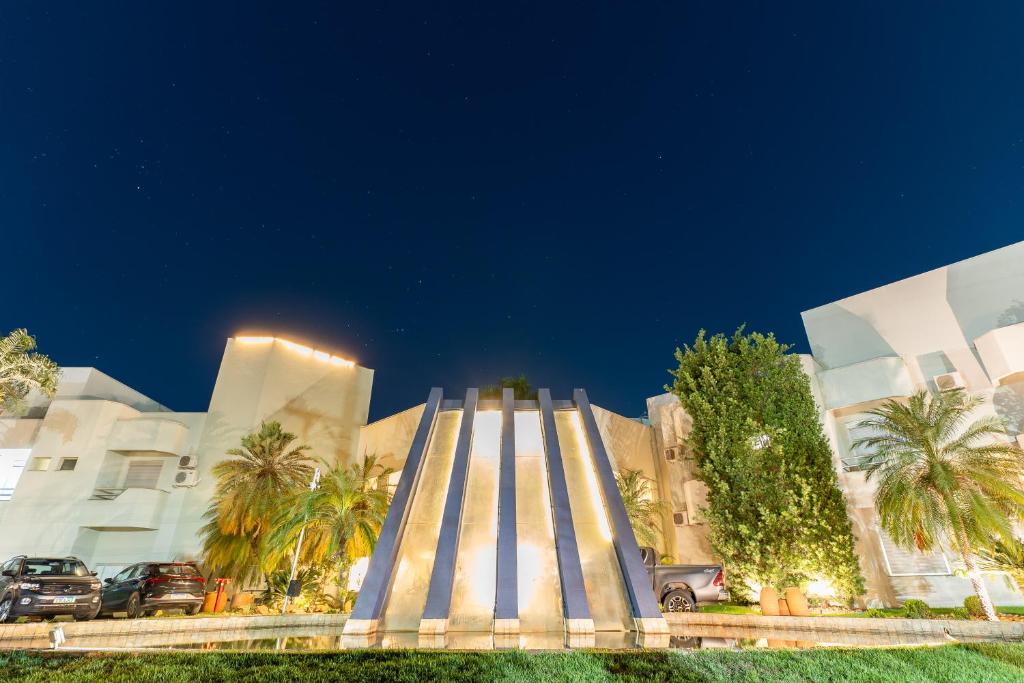 a building with palm trees in front of it at Ucayali Hotel in Sinop