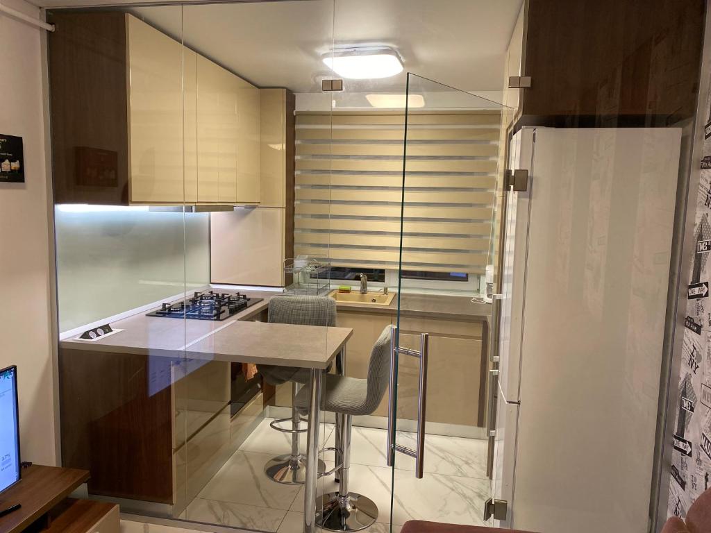 una cocina con mesa y algunas sillas. en Apartament modern -mobilat nou en Chiajna