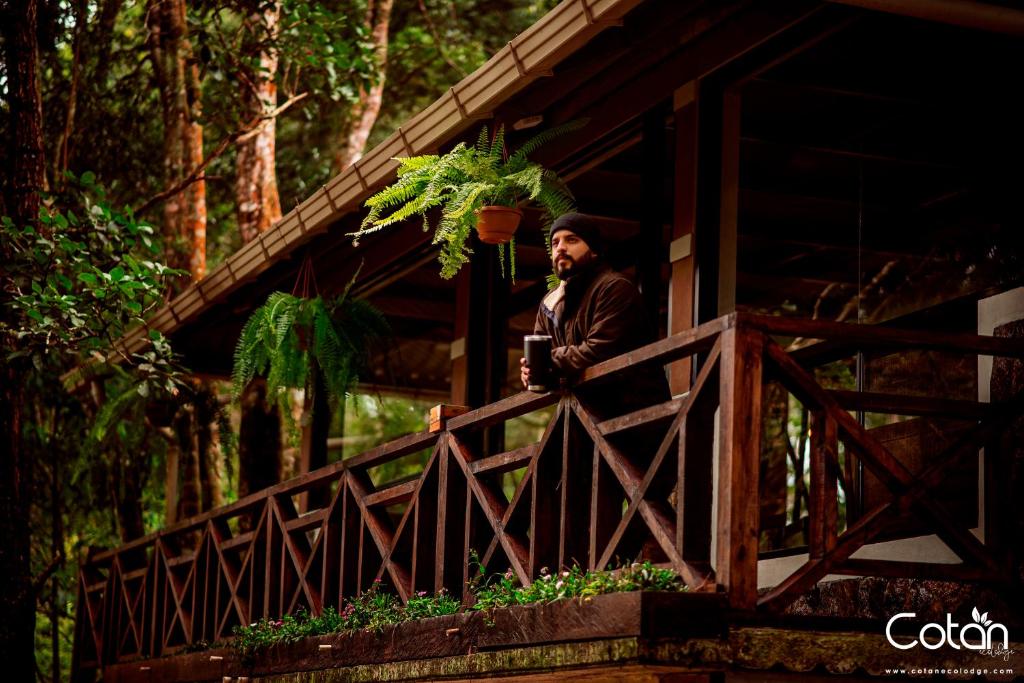 un hombre de pie en una valla en un puente en Cotan Ecolodge en La Esperanza
