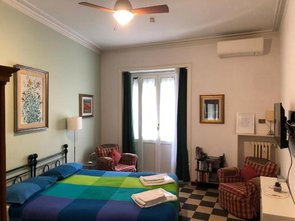 um quarto com uma cama, 2 cadeiras e uma janela em Flat for tourist use a stone's throw from center em Roma