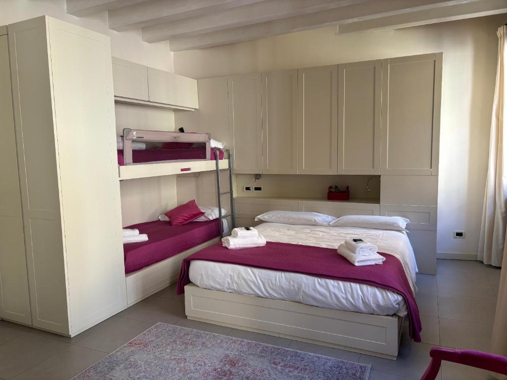 um quarto com 2 camas e lençóis roxos em Loft 17 Arena em Verona