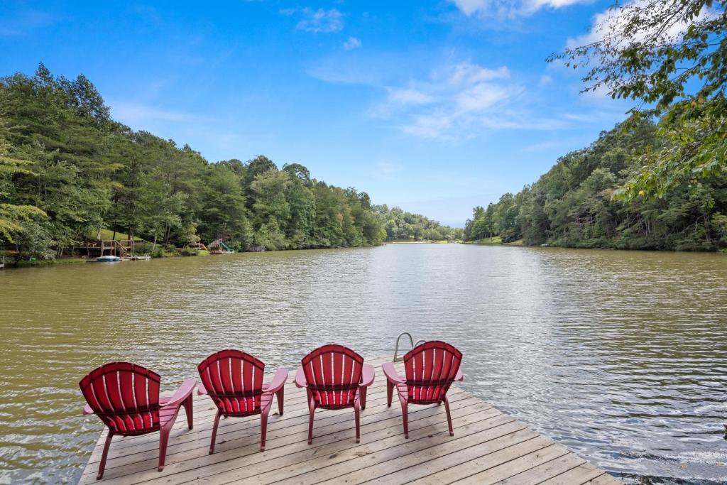 cuatro sillas rojas sentadas en un muelle junto a un río en Waterfront Lake Home-Private Dock on Mirror Lake-Kayak home, en Lake Lure
