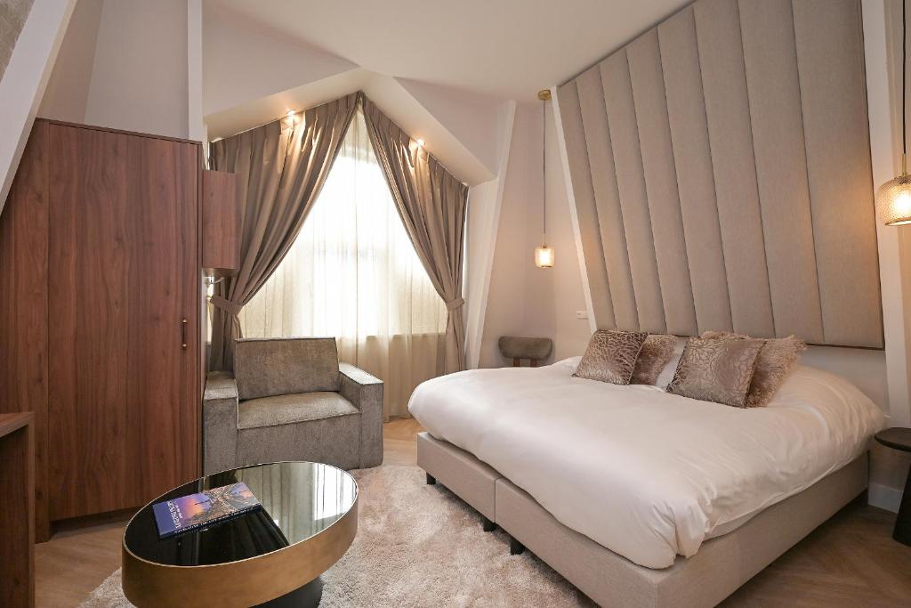 una camera d'albergo con letto e sedia di Novallure Downtown - Short Stay Apartments a L'Aia