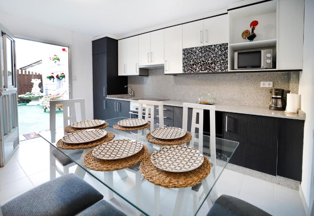 eine Küche mit einem Glastisch mit vier Torten drauf in der Unterkunft Casa Romero Garden in Vilanova de Arousa