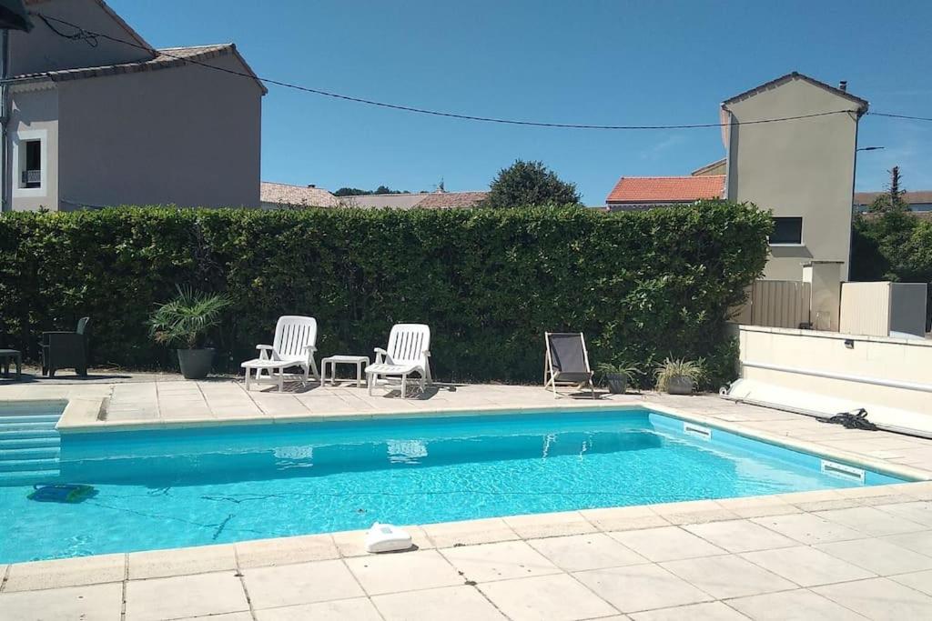 - une piscine avec 2 chaises longues dans l'établissement Grande Villa Ardèche, à Le Teil