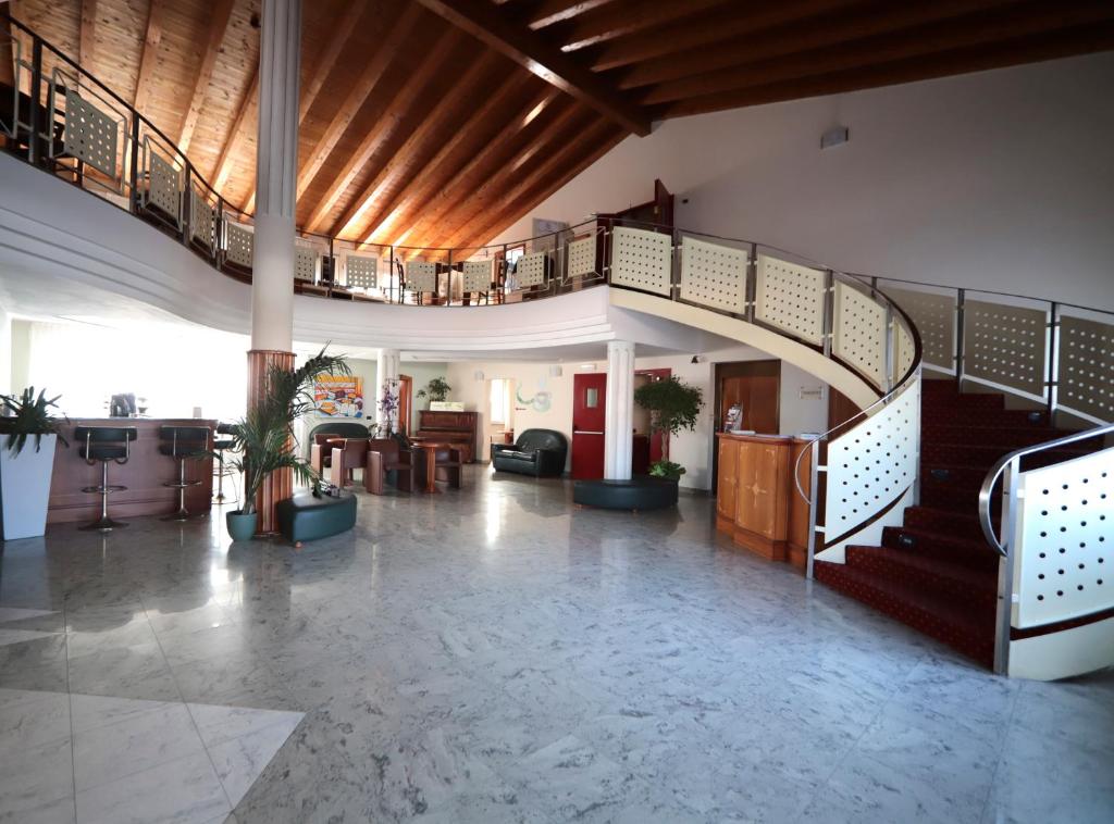 a lobby with a spiral staircase in a building at Hotel Riz B.B in San Genesio ed Uniti