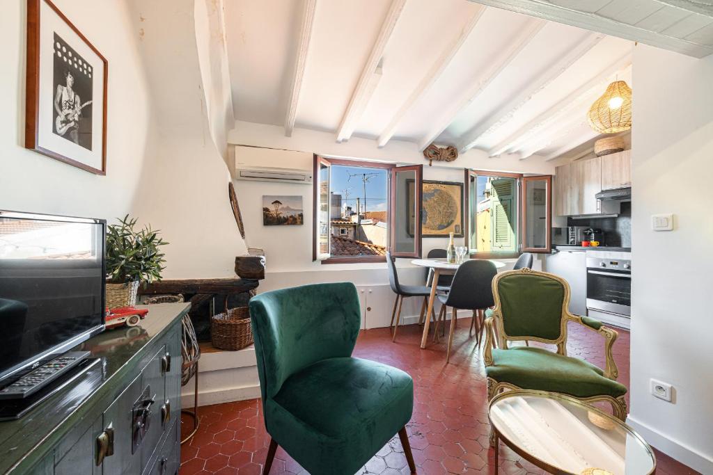 un salon avec des chaises vertes et une table dans l'établissement Charming Apartment Old Town, à Nice