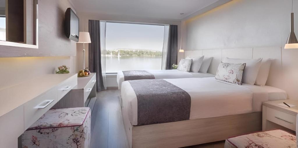ルクソールにあるNILE CRUISE LUXOR & ASWAN Aのベッド2台と大きな窓が備わるホテルルームです。