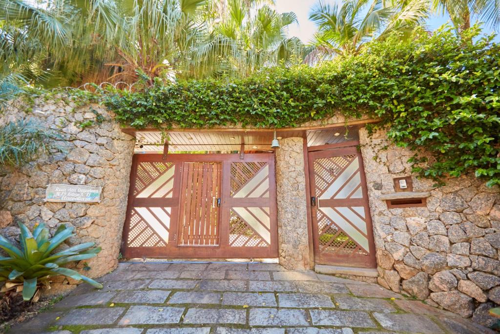 a wooden garage door on a stone wall with plants at Acolhedor em Niteroi - Ideal para familias - Recanto in Niterói