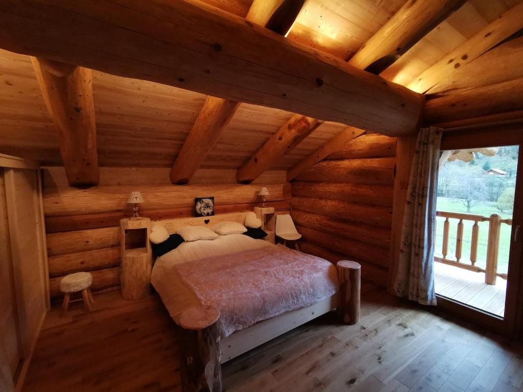 una camera con un letto in una baita di tronchi di Chalet 10 pers sauna & SPA La tanière des Vosges a La Bresse