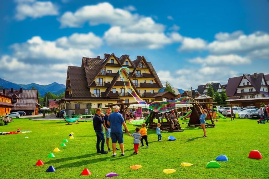 a group of people standing in a field with a kite at Helan Family & SPA in Zakopane