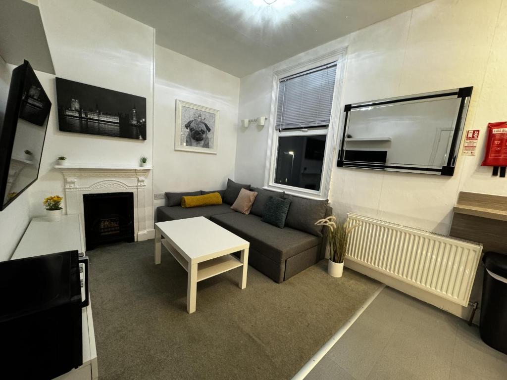 a living room with a couch and a fireplace at Onsite apartments in central Brentwood in Brentwood