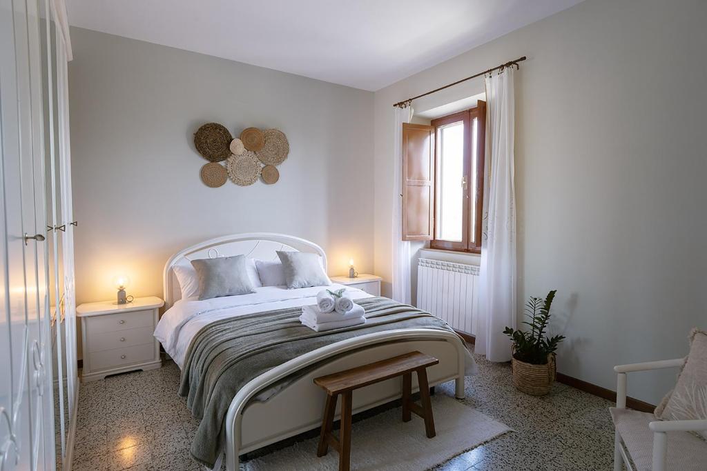 ein weißes Schlafzimmer mit einem Bett und einem Fenster in der Unterkunft ZEM casolare in Petriolo