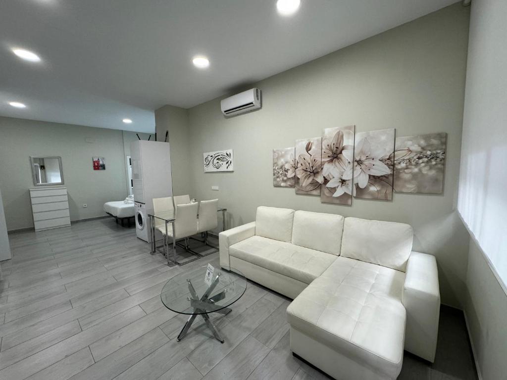 a living room with a white couch and a table at Garden City Lofts in Córdoba
