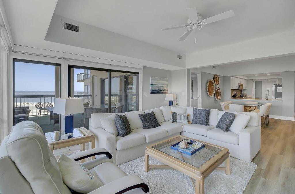 a living room with a couch and a table at 1408 Ocean Club by AvantStay Oceanfront Home w Amazing Views in Isle of Palms