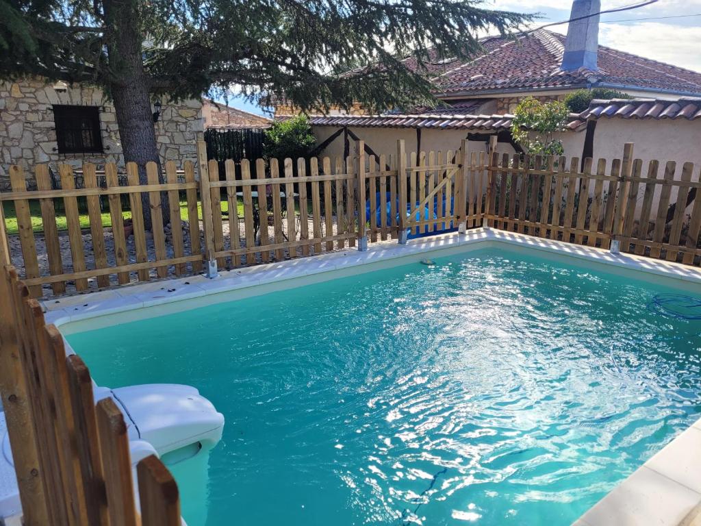 una piscina con una valla de madera y agua azul en Casa Rural Pedraza, en Pedraza-Segovia