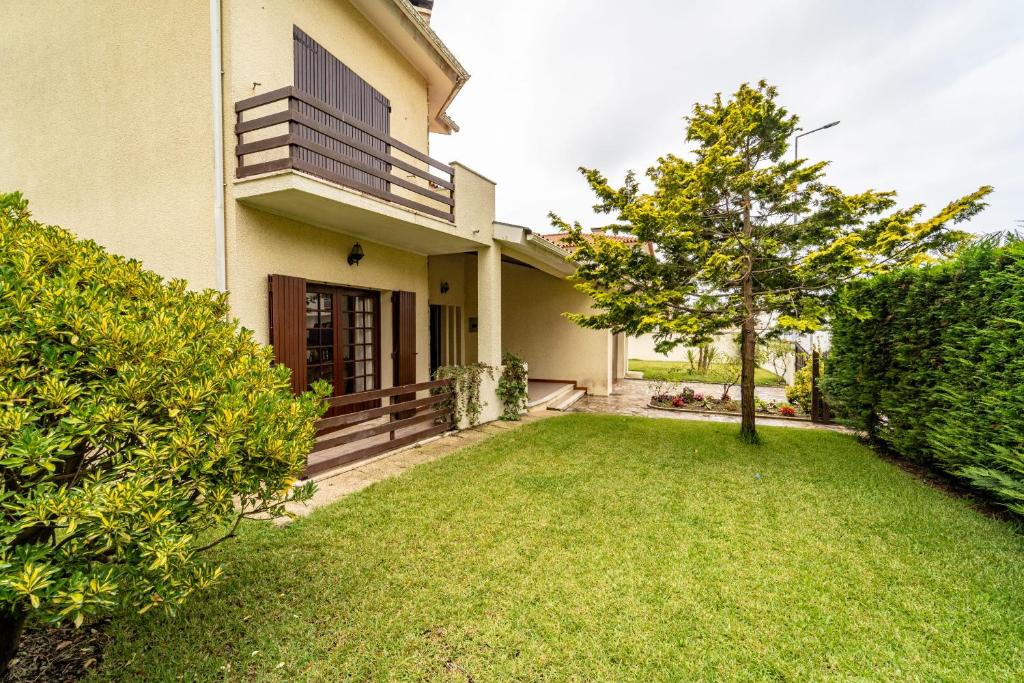 una casa con césped delante en Amorosa Villa, 500m from the beach by House and People en Amorosa