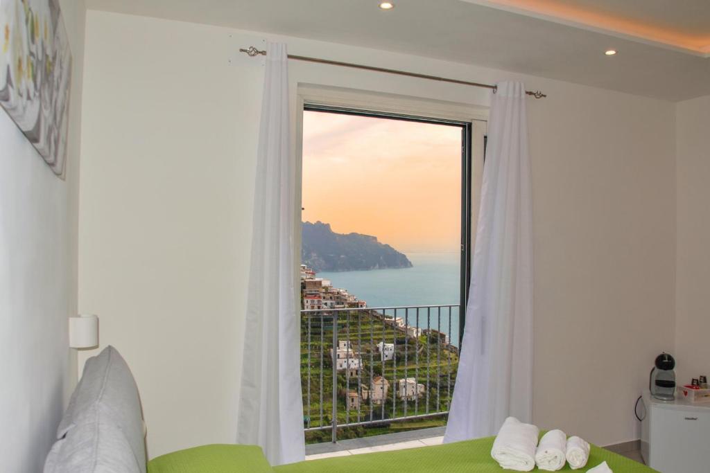 a room with a window with a view of the ocean at Amalfi Montemare Rooms in Amalfi