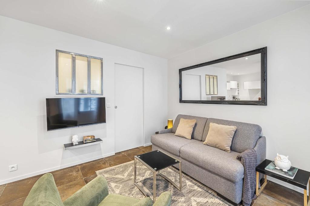 a living room with a couch and a mirror at Bella Citta in Paris