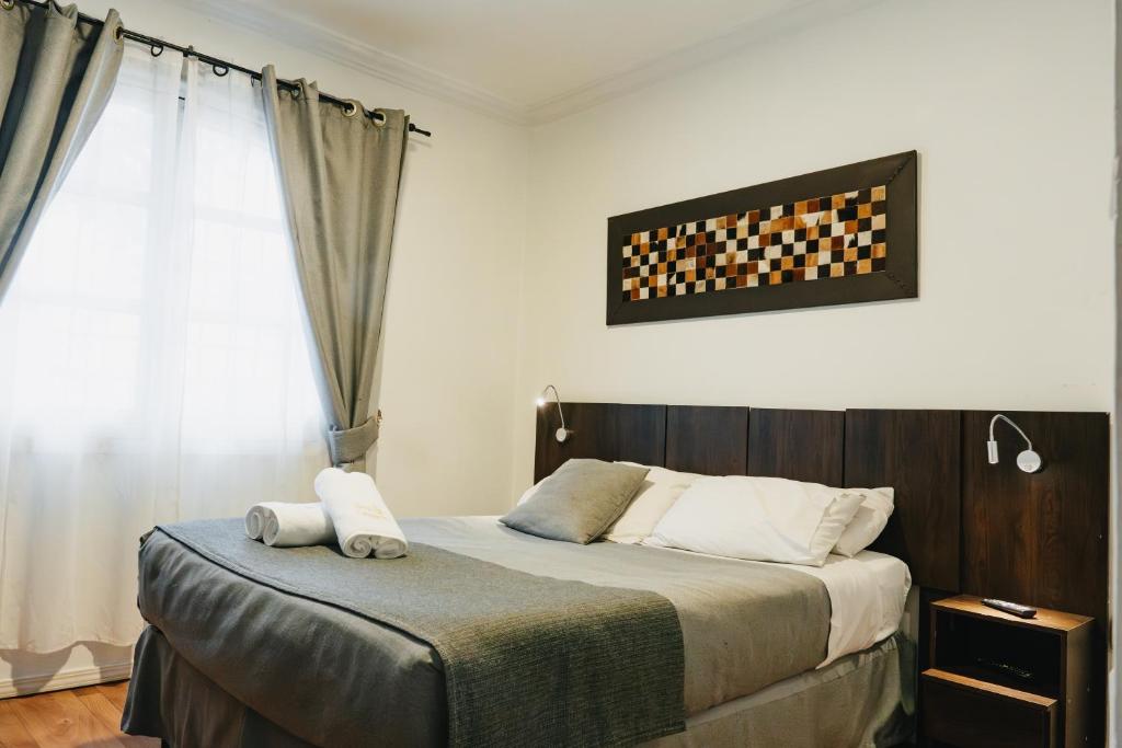 1 dormitorio con cama y ventana en Apart hotel de Hostal Concepción, en Concepción