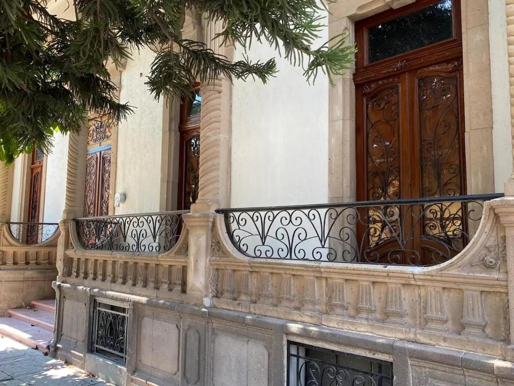 um edifício com uma varanda e uma porta de madeira em Casa La Cuarta em San Luis Potosí