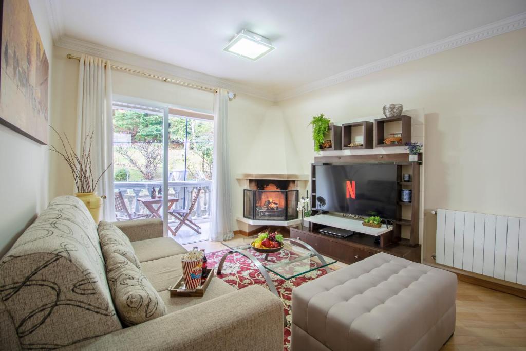 sala de estar con sofá y chimenea en 3 Quartos | Aconchegante | Ótima Localização, en Campos do Jordão