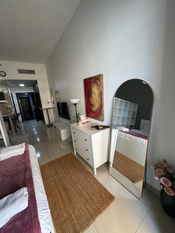 a bedroom with a mirror and a bed and a dresser at Studio Apartment near JBR in Dubai