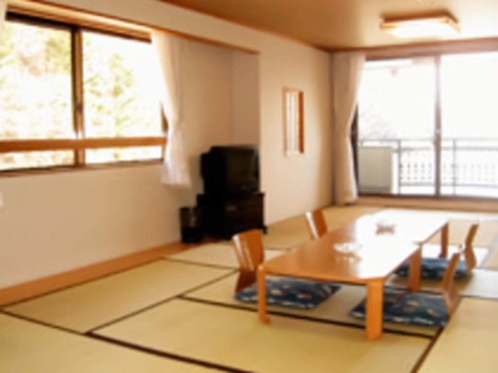 a living room with a wooden table and chairs at Shoji Mount Hotel - Vacation STAY 78001v in Narusawa