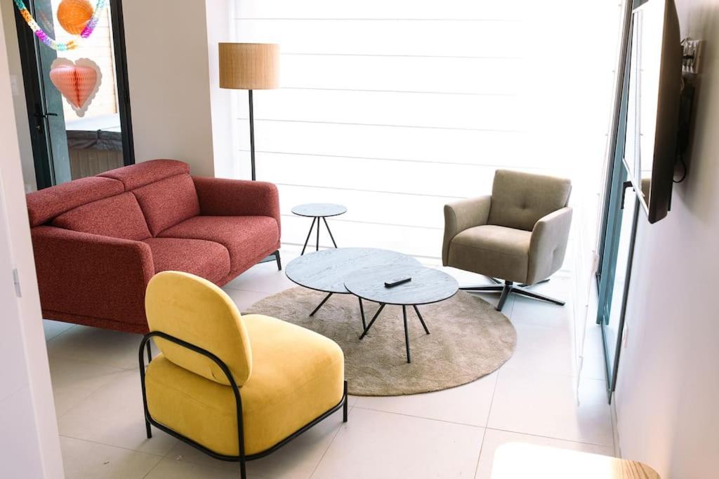 a living room with a couch and two chairs and a table at L&#39;orée de la Forêt in Desvres