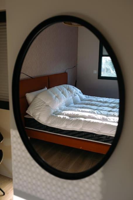 a reflection of a bed in a mirror at L&#39;orée de la Forêt in Desvres