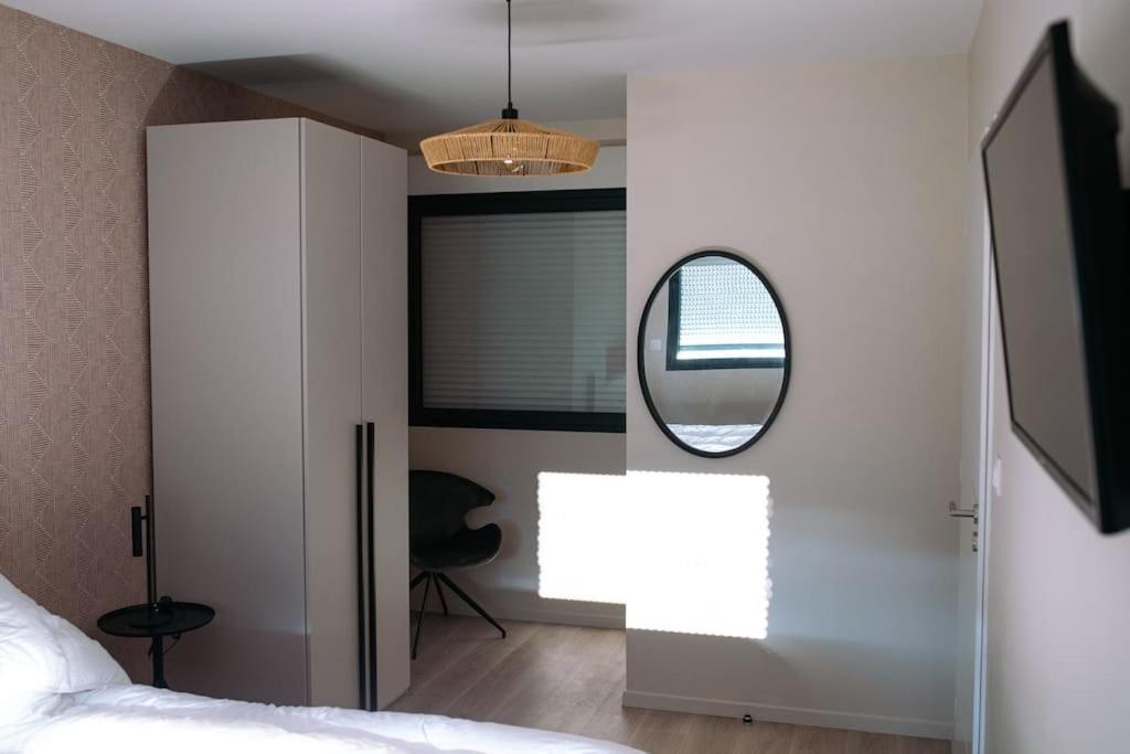 a bedroom with a mirror and a bed at L&#39;orée de la Forêt in Desvres