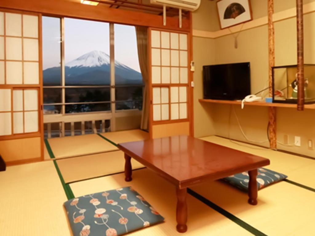 a living room with a table and a mountain view at Shoji Mount Hotel - Vacation STAY 83015v in Narusawa