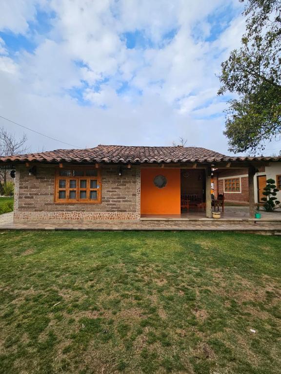 une maison avec une porte orange et une cour dans l'établissement cabañas en zacatlan, à Zacatlán