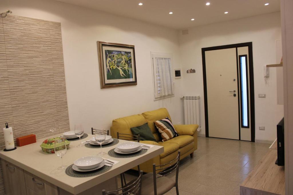 a living room with a yellow couch and a table at Villa CasArte in Bari