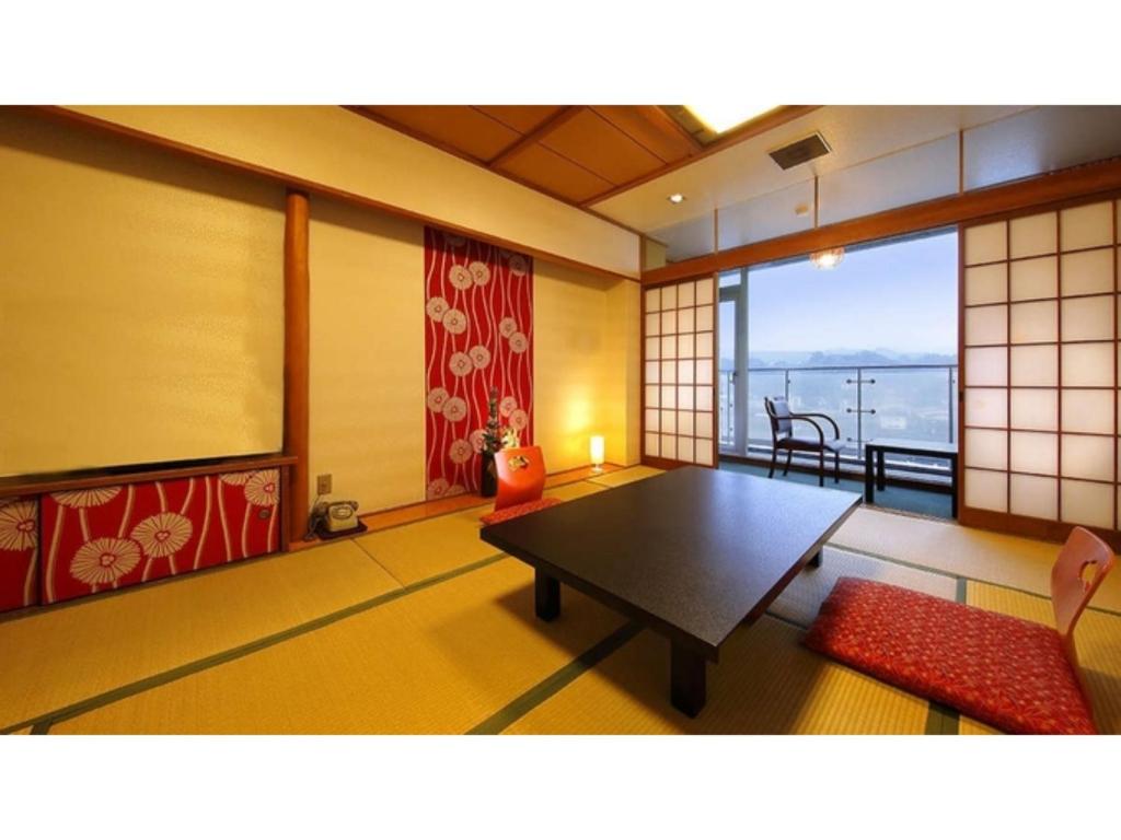 Sala de estar con mesa y vistas al océano en Mikuma Hotel - Vacation STAY 63441v en Hita