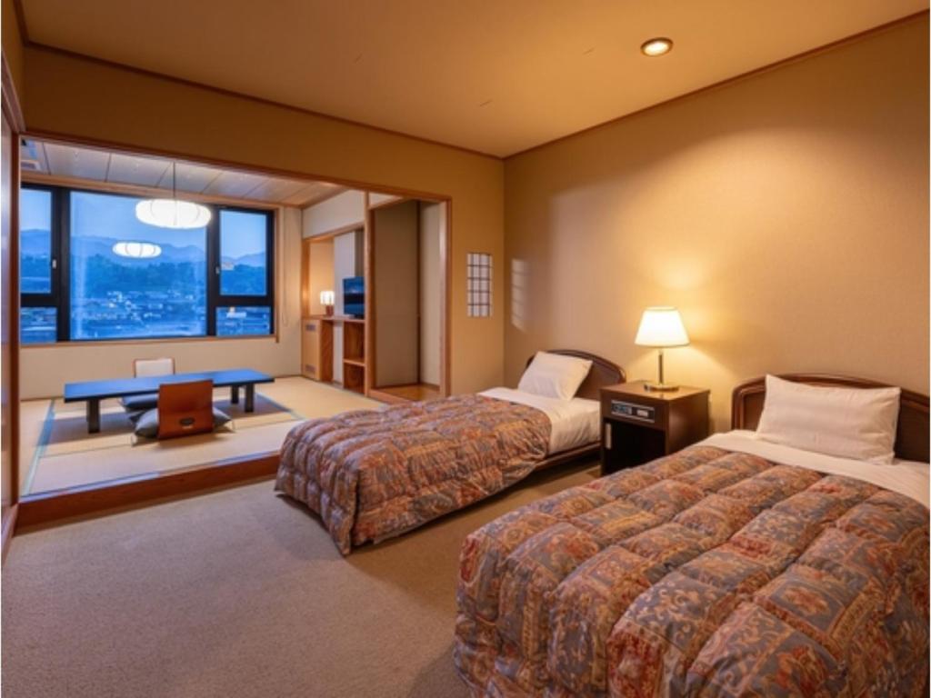 a hotel room with two beds and a window at Mikuma Hotel - Vacation STAY 63481v in Hita