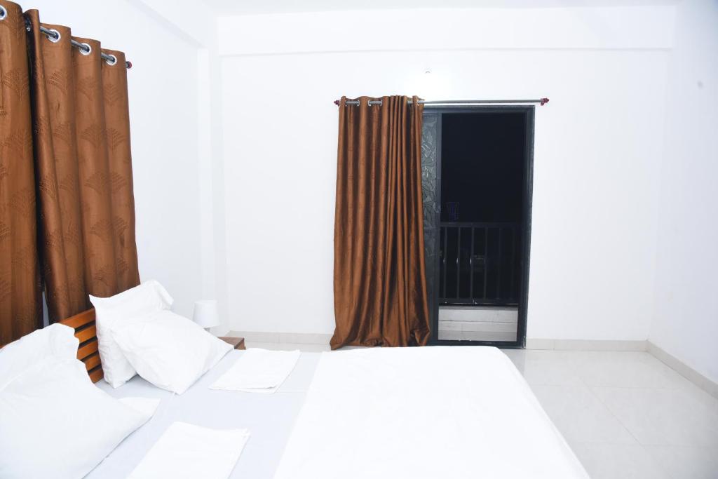 ein Schlafzimmer mit einem großen Bett und einem Fenster in der Unterkunft Hotel Relax in Solapur