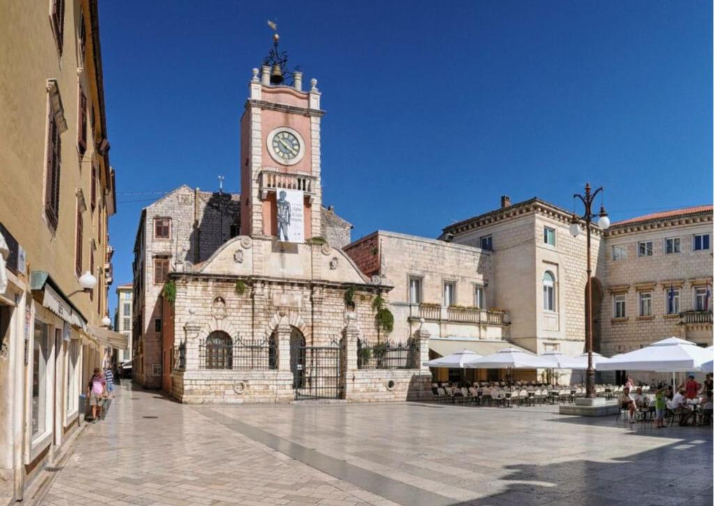 a large building with a clock tower in a city at Holiday Apartment Nina,Zadar in Zadar