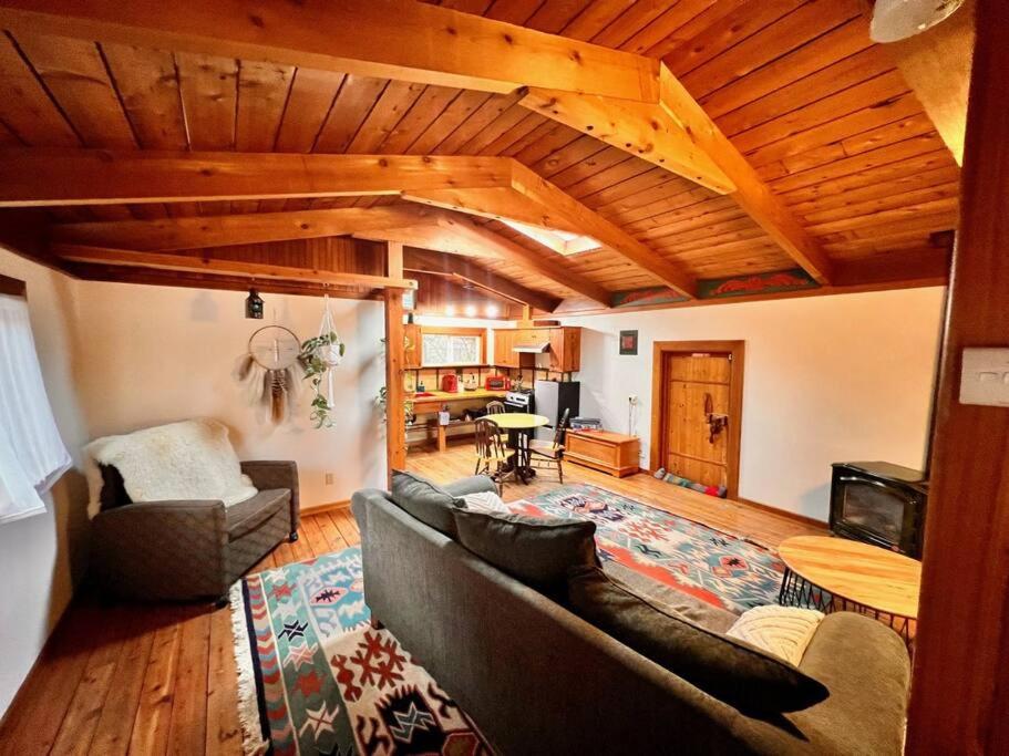 een woonkamer met een bank en een tafel bij Nostalgic Downtown Boatbuilder's Cabin - Licensed in Squamish