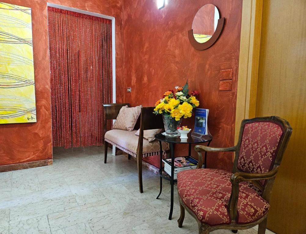 - un salon avec une chaise et une table fleurie dans l'établissement My sweet home, à Bari
