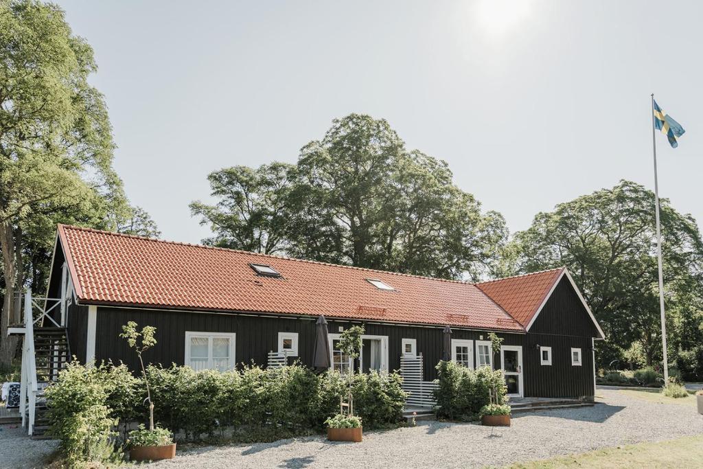 una casa negra con techo rojo en Skäftekärr Hotell och Konferens en Löttorp