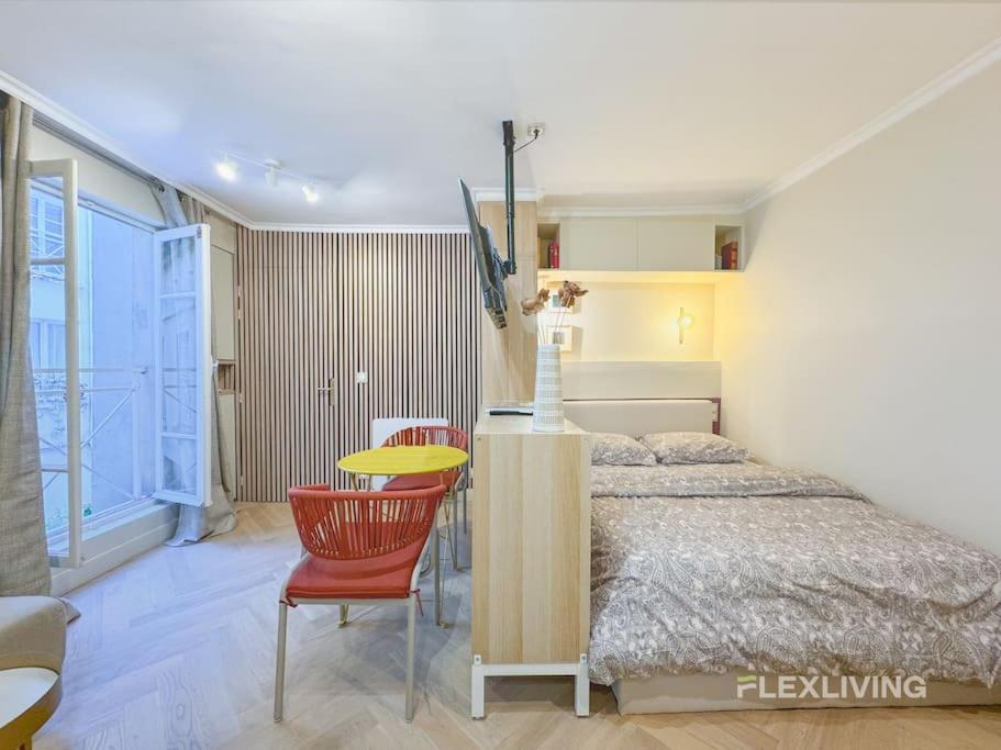 - une chambre avec un lit, une table et des chaises dans l'établissement Luxury Studio in city center, à Paris