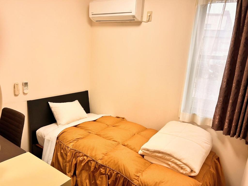 Hotel MitsuWakan - Vacation STAY 15763v في تسوشيما: غرفة صغيرة بها سرير ونافذة