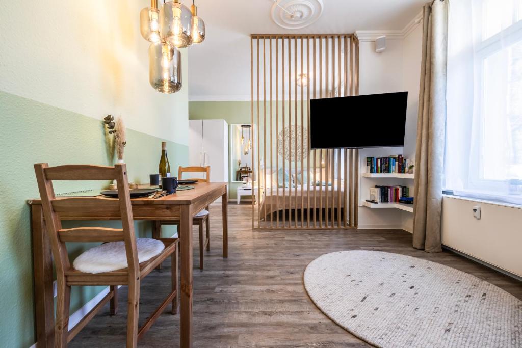 ein Esszimmer mit einem Tisch und einem TV in der Unterkunft Modern, gemütlich, zentral & nahe KarLi in Leipzig