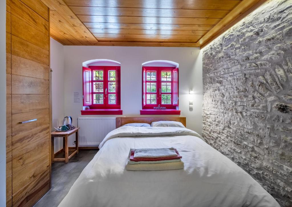 een slaapkamer met een groot bed en rode ramen bij The Land Beyond in Vitsa