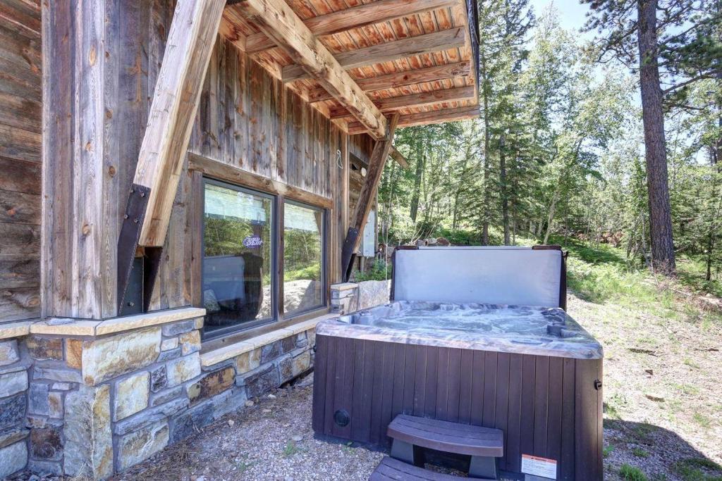 una vasca idromassaggio all'esterno di una baita di tronchi di Apres Powder Haus a Lead