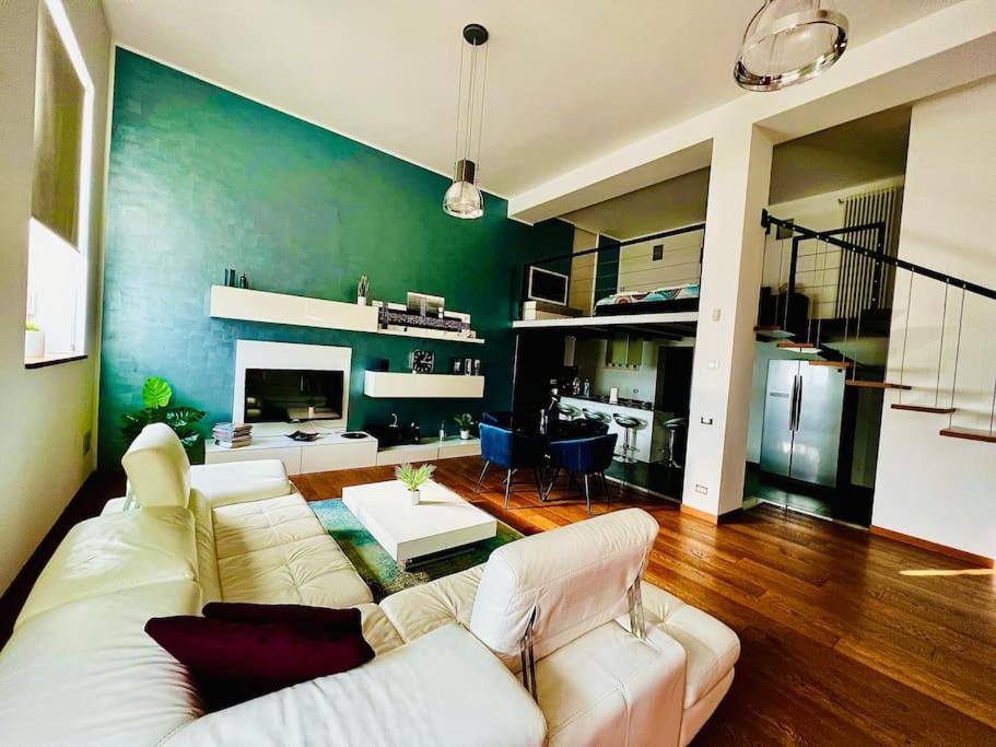 sala de estar con sofá blanco y pared verde en Moderno loft alle porte di Milano - 115mq - 3 posti en Cormano