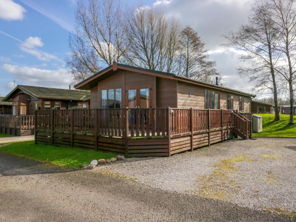 a large wooden house with a large deck at Lakeside 20 in Carnforth