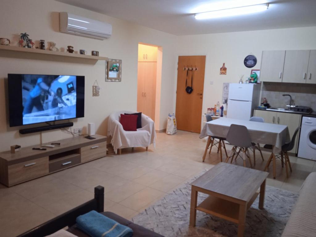 een woonkamer met een televisie en een keuken bij Xylophagou Rest and Relax 3 Ayia Napa Larnaca 1 bedroom apartment in Xylophaghou