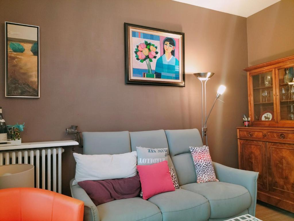 ein Wohnzimmer mit einer blauen Couch mit bunten Kissen in der Unterkunft Villa 300m de la plage in Le Touquet-Paris-Plage